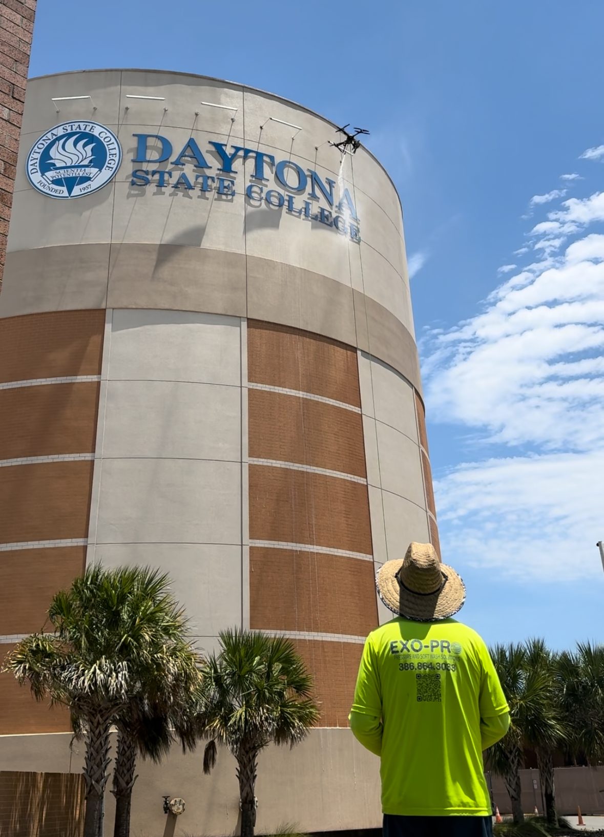 Exo-Pro operator flying a soft wash drone against the Daytona State College water tower